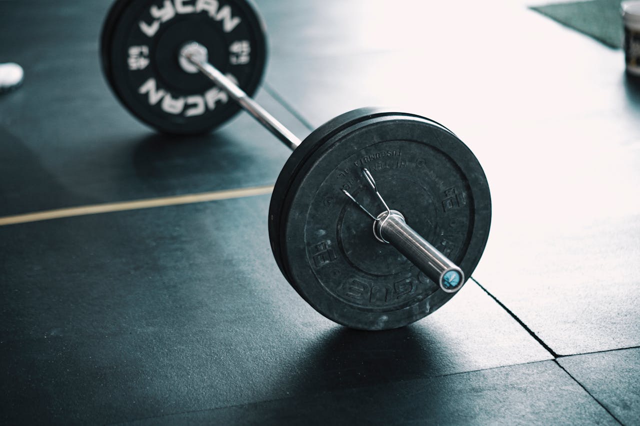 gallery-6 A detailed image of a barbell resting on a gym floor, perfect for fitness themes.