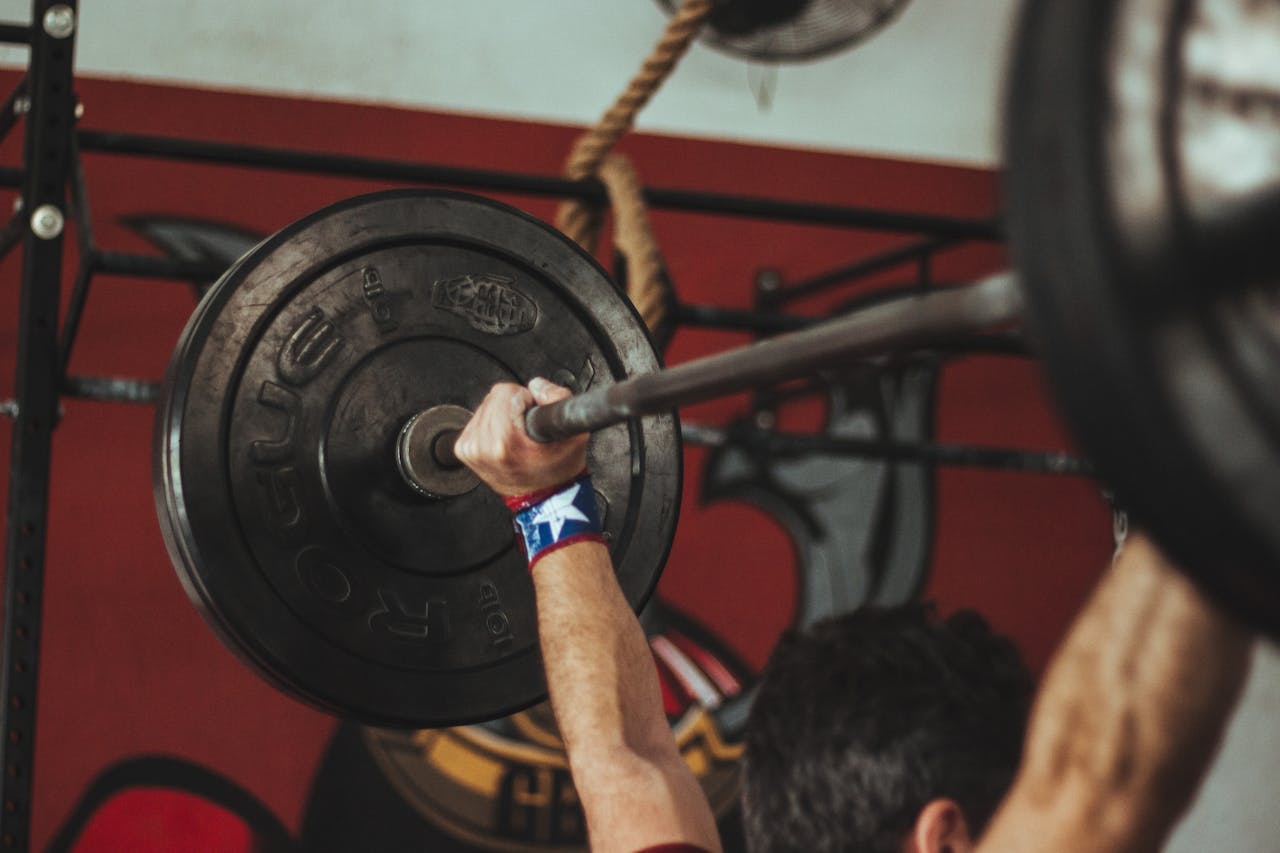 hero-img-01 Athlete lifting heavy barbell during strength training session in gym.